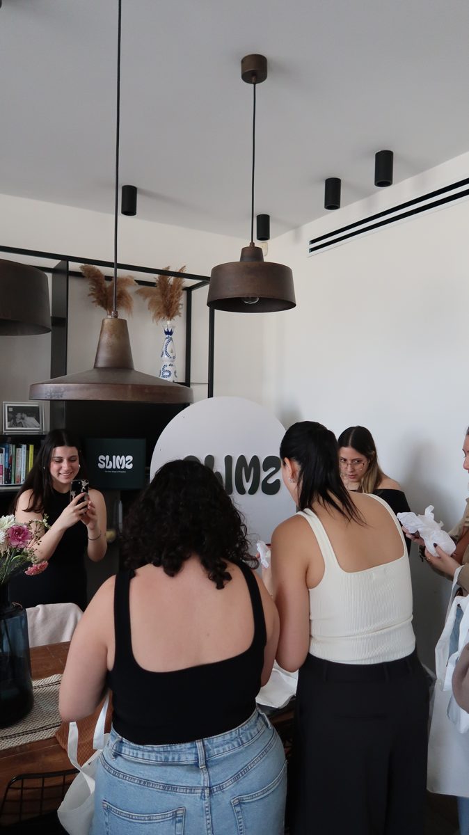 Women in SLIMZ tops by the SLIMZ sign