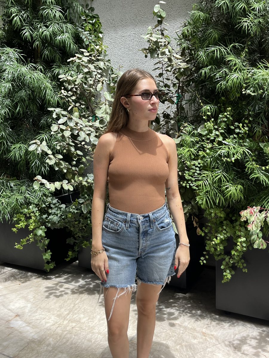 A SLIMZ customer in a High Neck Top and denim shorts